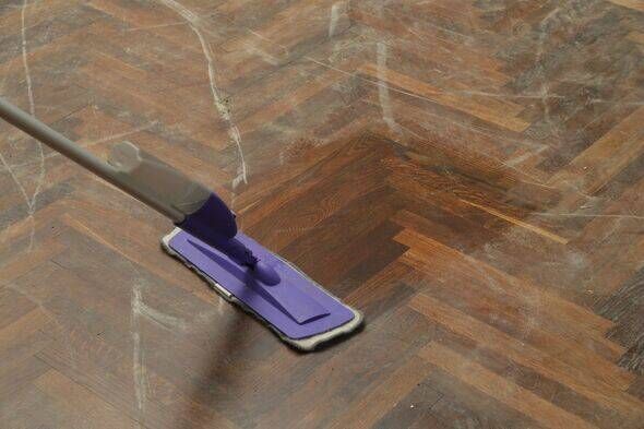 Woman mopping the very dusty wooden floor